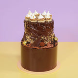 2 Tier Ferrero & Chocolate Cake with rich chocolate icing, hazelnut truffles, meringues, and gold leaf decoration by Crumbs & Doilies